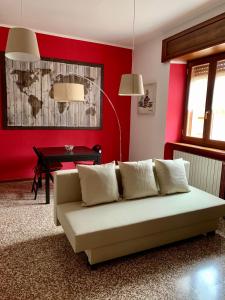 ein Wohnzimmer mit einem Sofa und einer roten Wand in der Unterkunft La casa di Marty B&B in Berceto
