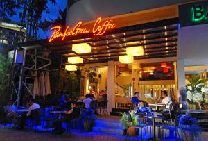 people sitting at tables outside of a restaurant at night at Bamboo Green Riverside Hotel in Danang