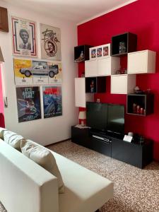 salon z czerwoną ścianą i telewizorem w obiekcie La casa di Marty B&B w mieście Berceto