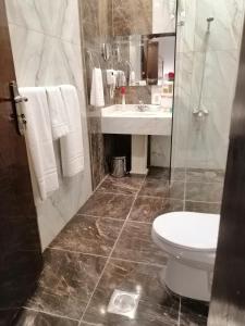 a bathroom with a toilet and a sink at Central Park Hotel Bisha in Qal'at Bishah