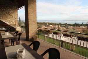 Un balcón con mesas y sillas y vistas. en Agriturismo Cascina Crocelle, en Padenghe sul Garda