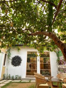 a house with a table and chairs under a tree at The Art Hotel by VIA VARANASI in Varanasi