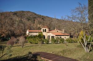 a large white house with a hill in the background at Le Parc - Suite climatisée in Magrie