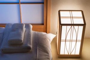 a bed with a blue blanket and a mirror at Karasuma Rokujo Hotel / Vacation STAY 3038 in Kyoto