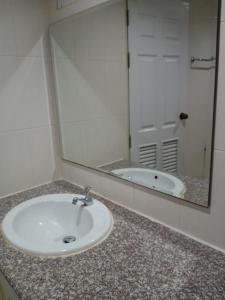 lavabo con espejo y bañera en โรงแรมไดมอนด์แกรนด์ เฮ้าส์ แอนด์ รีสอร์ท en Chiang Mai