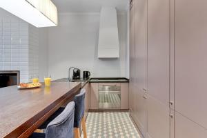 a kitchen with a wooden counter and a table at Kings Court - Neptun Park in Gdańsk