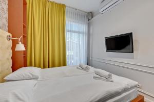 a hotel room with two beds and a television at Kings Court - Neptun Park in Gdańsk