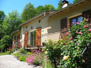 a house with a bunch of flowers in front of it at Le Moulin du Barthas in Montredon-Labessonnié