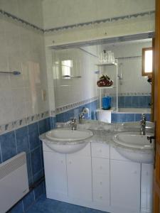 a bathroom with two sinks and a mirror at Le Moulin du Barthas in Montredon-Labessonnié