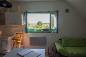 Cette chambre dispose d'une fenêtre, d'une table et d'une chaise. dans l'établissement Appartement en campagne a 1h30 de Paris, à Foucrainville