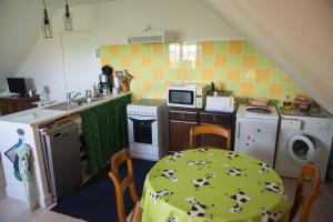 une petite cuisine avec une table et un tissu de table vert dans l'établissement Appartement en campagne a 1h30 de Paris, à Foucrainville