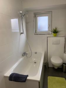 ein weißes Bad mit einer Badewanne und einem WC in der Unterkunft Work & Study Apartment in Karlsruhe
