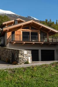 een blokhut met een veranda en een balkon bij CHALET ALTAÏ in Séez