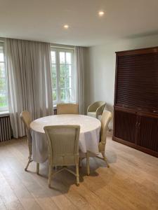 a dining room with a white table and chairs at House Zoute Stables 125sqm in 5 Ha property near seaside in Knokke in Knokke-Heist