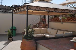 eine Terrasse mit einem Sofa unter einem Pavillon in der Unterkunft Lodges le Mura in Florenz