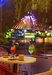 a table with two drinks on it in front of a window at Bamboo Green Riverside Hotel in Danang
