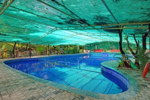 a large swimming pool with a blue roof at Van Vihar Resort in Sasan Gir