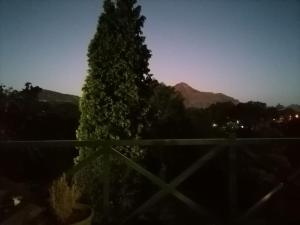 a tree in front of a mountain at night at Clarens on Collett in Clarens