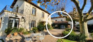 una casa bianca con un tavolo e sedie di fronte di La Parenthèse, Rez de jardin indépendant, 4 étoiles a Fleurieu-sur-Saône
