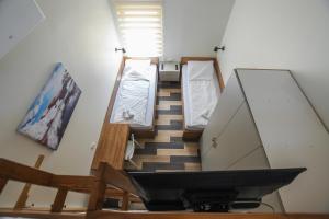 Hostel Atrijum في كلادوفو: غرفة بثلاث اسرة في غرفة بها تلفزيون