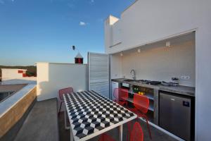 uma cozinha com uma mesa xadrez e cadeiras vermelhas em Casa Xonar em Silves