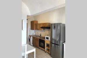 a kitchen with a stainless steel refrigerator and wooden cabinets at Apartamento en La Pared Fuerteventura vista mar in Pájara