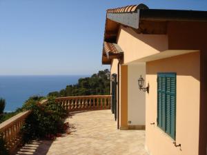 Villa Riviera في Latte: مبنى فيه باب أخضر وبلكونه