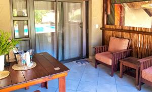 iKhaya LamaDube Game Lodge في Klipdrift: غرفة معيشة مع طاولة وكرسي وطاولة