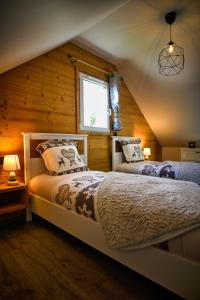 1 Schlafzimmer mit 2 Betten und einem Fenster in der Unterkunft Le Domaine d'Emma : Le Golden in Soultzeren