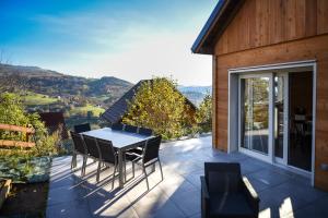 a table and chairs on a patio with a view at Le Domaine d'Emma : Le Golden in Soultzeren