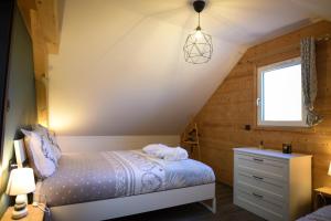 a attic bedroom with a bed and a window at Le Domaine d'Emma : Le Golden in Soultzeren