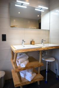 a bathroom with two sinks and a mirror at Le Domaine d'Emma : Le Golden in Soultzeren +8 photos