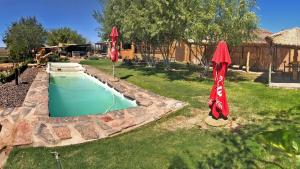 a swimming pool with two umbrellas in a yard at Frontier River Resort in Vioolsdrif