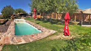 ein Pool mit zwei Sonnenschirmen im Hof in der Unterkunft Frontier River Resort in Vioolsdrift