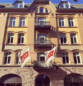 un edificio con dos banderas delante en Clarion Collection Hotel Norre Park, en Halmstad