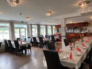 a dining room with long tables and chairs at Eidsvåg Fjordhotell in Eidsvåg