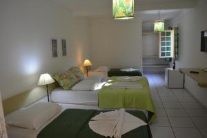 a living room with two beds and a couch at Capitania Praia Hotel Fazenda in Porto Seguro