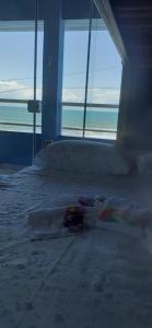 Schlafzimmer mit einem Bett und Meerblick in der Unterkunft Pé na areia apt superior in Itapoa