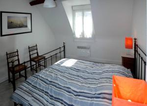 ル・トレポールにあるVilla Normandeのベッドルーム1室(ベッド1台、椅子2脚、窓付)