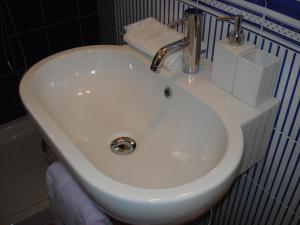 a white sink with a faucet in a bathroom at Residenza Levante in Siracusa +17 photos
