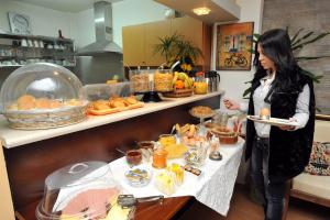 una mujer sosteniendo un plato de comida en un buffet en Apollon Hotel, en Argos
