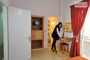 Uma mulher está de pé numa mesa num quarto. em Apollon Hotel em Árgos
