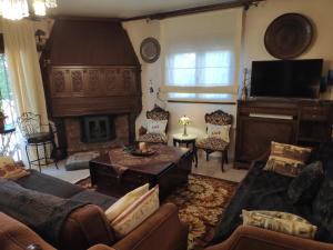 uma sala de estar com um sofá e uma lareira em British Wood 'n Stone House em Tessalônica