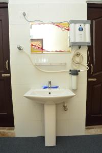 a bathroom with a white sink and a mirror at Tranquil AC Budget Room( Single, Family & Group) in Bhubaneshwar