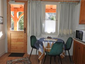 une cuisine avec une table et des chaises ainsi qu'une fenêtre dans l'établissement Le Lioran Studio les Myrtilles à 200m des pistes, à Le Lioran