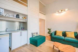 a living room with a green couch and a table at Hyper centre - Cathédrale in Reims