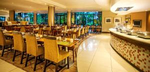 a restaurant with wooden tables and chairs and a bar at Garden Court Hatfield in Pretoria