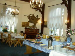 a dining room with tables and chairs and chandeliers at Hotel-Pension Seeblick in Kühlungsborn