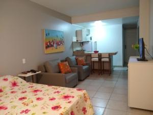 um quarto com uma cama, um sofá e uma mesa em Farol da Barra 209 em Salvador