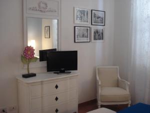 a room with a television on a dresser with a chair at Residenza Levante in Syracuse
